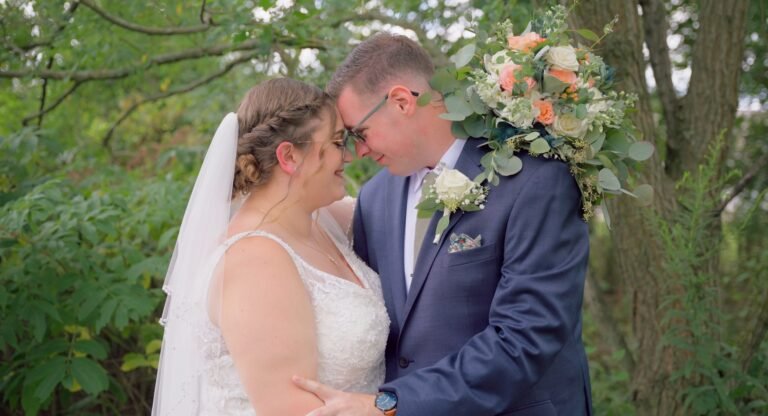 wedding couple heads together infront of trees