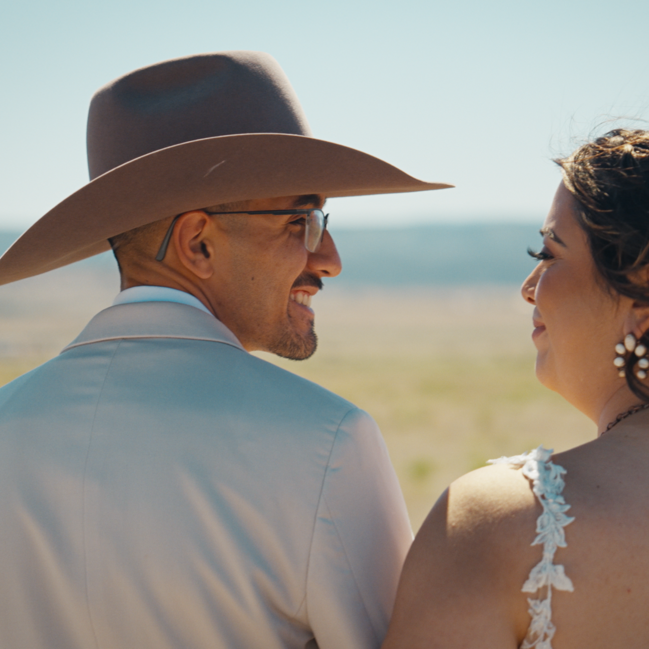 Bride and groom in western wedding attire sharing a candid moment