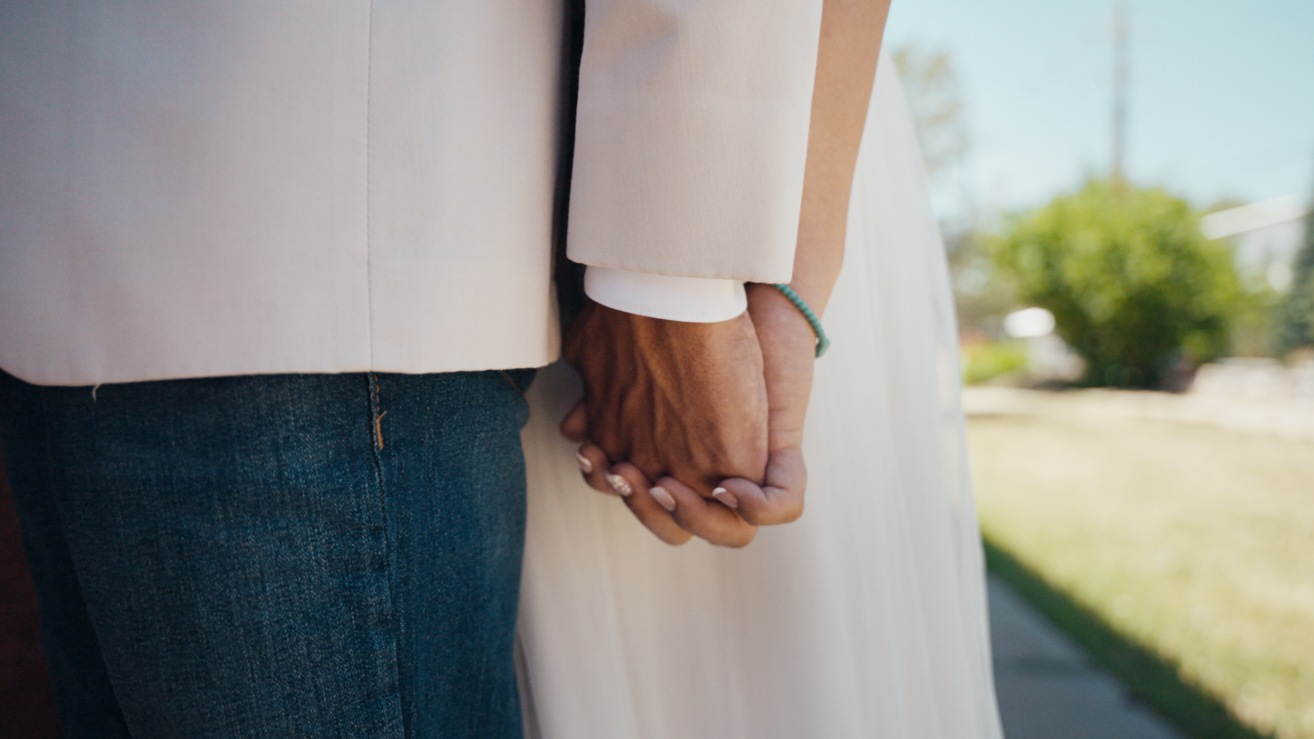 Close-up of the bride and groom holding hands.