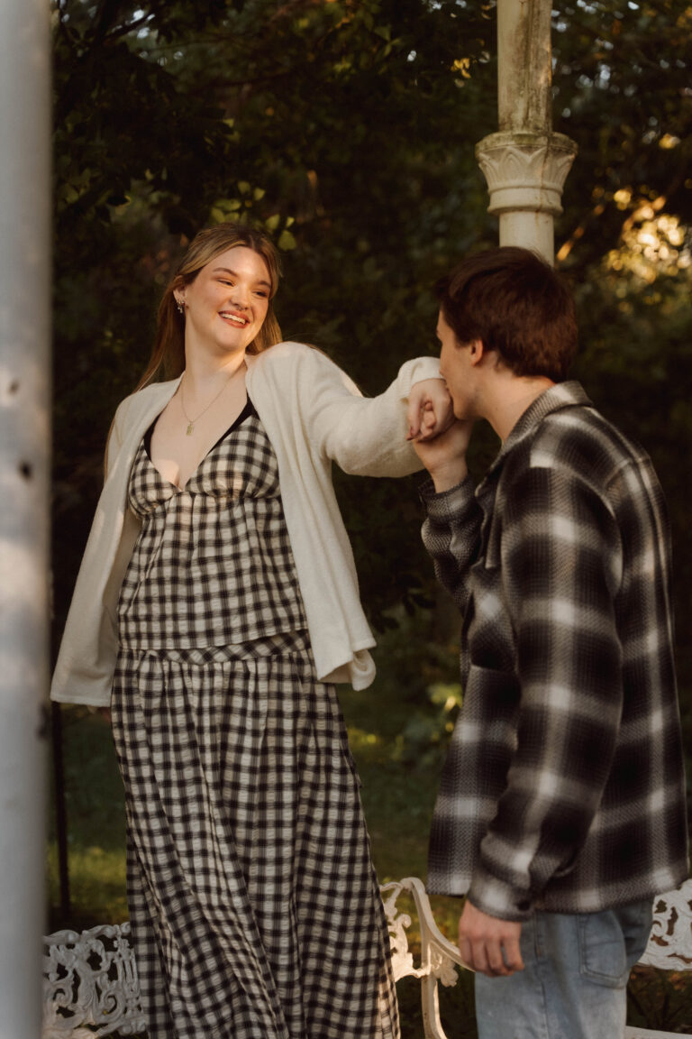 man kissing his partner on the hand while she smiles at him
