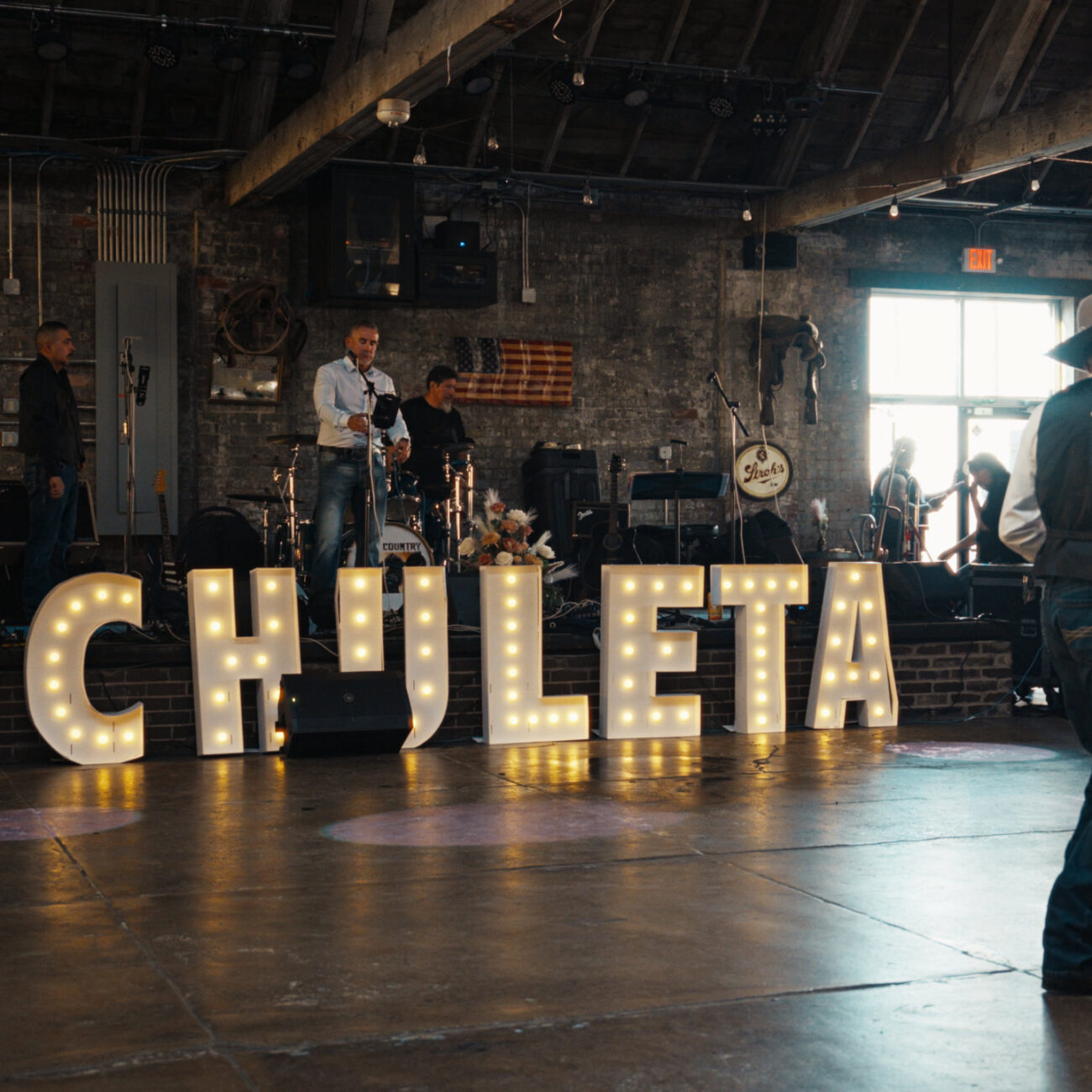 Wedding reception dance floor with illuminated ARCHULETA marquee letters